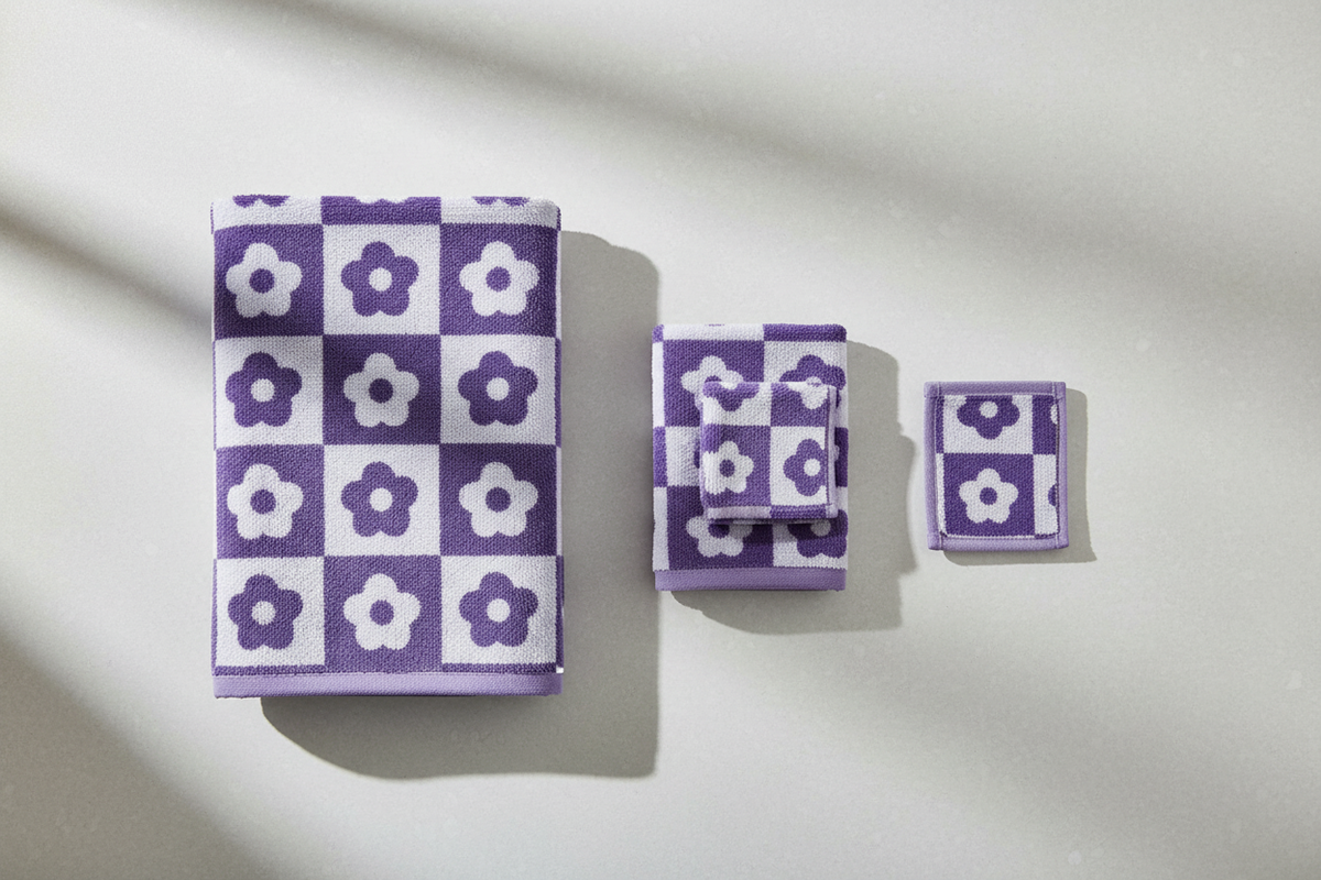 Purple checkerboard floral coral fleece towel set flat lay on light grey surface