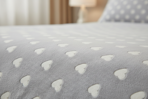 Close-up of light gray heart print microfiber sheet showing pattern and fabric texture
