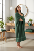 Woman wrapped in hunter green popcorn textured cotton bath towel in natural bathroom