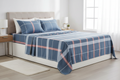 Blue plaid cotton sheet set front-facing view on a neatly made bed in a bright minimal bedroom